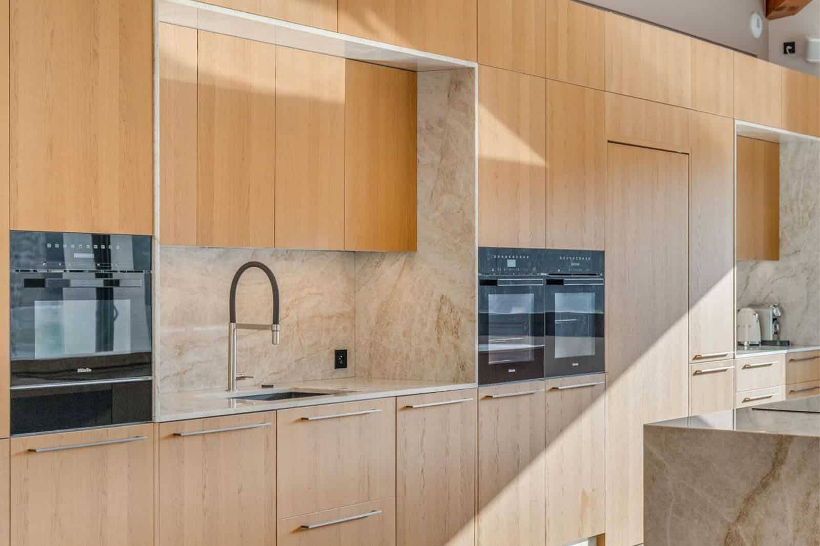 Création d'une grande cuisine italienne sur mesure avec un mélange de finitions bois clair et pierre dans le Var à Bandol