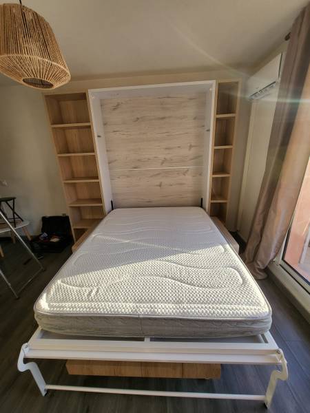 Dans un studio proche de la Ciotat, installation d'un lit escamotable confortable et de bibliothèques sur-mesure 